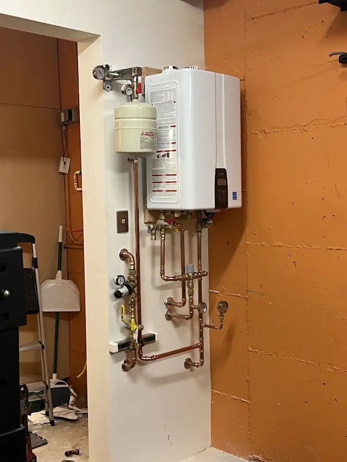 Plumbing technician inspecting water heater connections in Donna